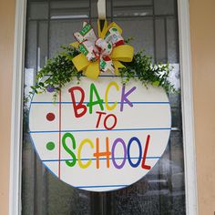 a back to school sign hanging from the side of a door with ribbons and bows on it