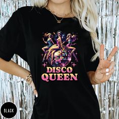 Step into the spotlight and let your inner Disco Queen shine with our exclusive Retro Vibes Disco Queen T-shirt! Designed for those who love to dance through the decades, this tee is a perfect blend of style and comfort. Embrace the groove and express your love for disco music with every step. .: 6.1 oz., 100% ring spun USA cotton .: Preshrunk, soft-washed, garment-dyed fabric .: Made with sustainably and fairly grown USA cotton & sewn with USA cotton thread .: Relaxed fit & Sewn-in Twill Label .: Print Method: DIGISOFT® SIZE GUIDE Tees are Unisex so have a slightly oversized look on women, we recommend you to go down a size for a slimmer fit. Fit is truer to size for men. You can find the size guide in the listing photos with measurements in inches for garment width and body length. Pleas Vintage Summer Party T-shirt, Vintage Party Tops With Letter Print, Vintage Letter Print Tops For Party, Party T-shirt With Funny Print, Party T-shirt With Text Print, Party T-shirt With Text Print And Short Sleeves, Retro Graphic Print Party Tops, Retro Party Tops With Graphic Print, Retro Screen Print Tops For Festival