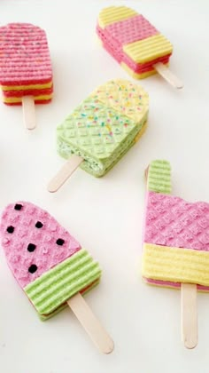 four popsicles made out of waffles with different colors and designs on them