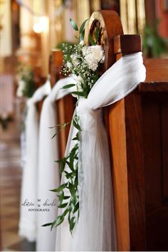 flowers are tied to the pews at a wedding