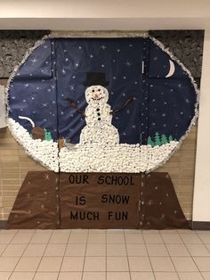 a bulletin board with a snowman on it in the middle of a school hallway