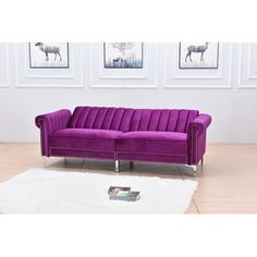 a purple couch sitting on top of a white rug