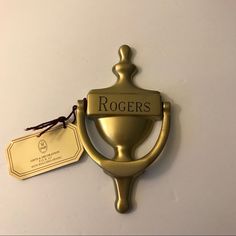 a gold bottle opener with the name rogers on it and a tag attached to it