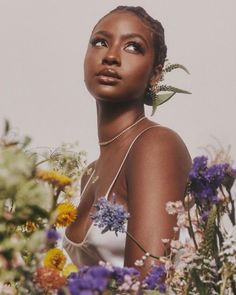 a woman in a white dress surrounded by flowers