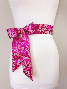 "Hot Pink Sash in Asian Brocade Pink Floral Sash in Gold Satin Brocade Hot Pink Obi Belt, Kimono Sash Chinese Brocade Sash Satin Swank Elevate your style instantly with this Satin Swank® Asian brocade sash in hot pink and floral gold. Sometimes called Chinese brocade, satin brocade, or silk brocade, this is a weighty fabric intricately woven into an elaborate pattern. At two inches wide and 75 inches long, this brocade sash will give most waist sizes the option of tying it in a bow with short ta Elegant Fitted Pink Sashes, Fitted Sashes With Satin Bow, Formal Sashes With Matching Belt, Chinese Brocade, Belt Kimono, Floral Sash, Pink Sash, Open Sweater, Obi Belt