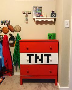 there is a red dresser with the word tht on it in front of pictures