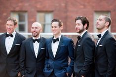 a group of men in tuxedos standing next to each other