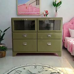 a room with a bed, dresser and clock on the wall next to each other