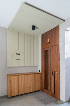 an entry way with a wooden door and large mirror on the wall next to it