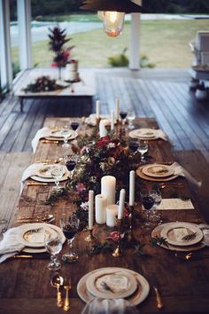 the table is set with candles, plates and place settings for dinner guests to enjoy