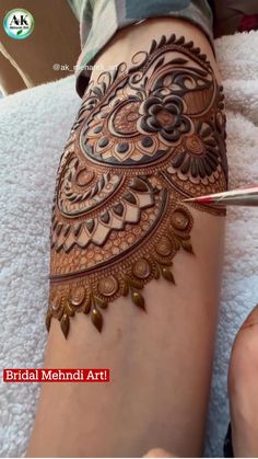 someone is getting henna done on their arm and leg, with the words bridal mehndi art