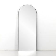 an arched mirror sitting on top of a white counter