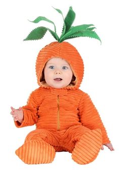 a baby dressed in an orange outfit with a green leaf on top