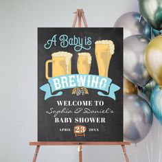 a baby is brewing welcome sign with balloons in the background