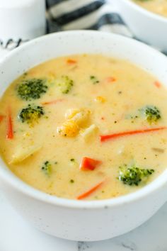 two bowls of soup with broccoli and carrots