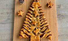 a christmas tree shaped pastry sitting on top of a wooden cutting board