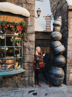 a woman standing in front of a building with decorations on the outside and inside it