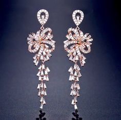 A delightfully unique pair of bridal earrings with an incredible sparkle! Adorned with flawlessly faceted cubic zirconia that capture the light in a dazzling array of sparkles, the earrings are rhodium plated for a bright finish which enhances the intricate detailing and conveys a modern take on old elegance. Length: 60mm (approx. 2.3"). Width: 18mm (approx. 0.7"). Weight: 11g. Available in Silver and Rose Gold finishes. To make your choice select your preferred finish from the dropdown menu to Cubic Zirconia Bridal Earrings, Bridal Jewellery Earrings, Bridal Earrings Chandelier, Wedding Bride Jewelry, Bridal Women, Bridal Earrings Drop, Silver Wedding Jewelry, Wedding Party Jewelry, Sparkly Earrings