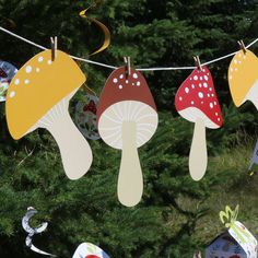 paper mushrooms are hanging on a clothes line