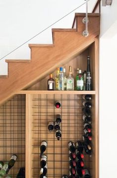 the wine rack under the stairs is filled with bottles