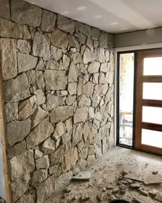 an unfinished room with a stone wall and door