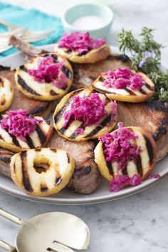 a white plate topped with meat covered in pink cabbage