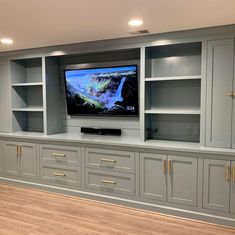 a flat screen tv mounted to the side of a wall in a home entertainment center