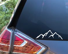 a car with mountains decal on it's rear window and the tail end