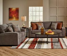 a living room with two couches, a coffee table and a rug on the floor