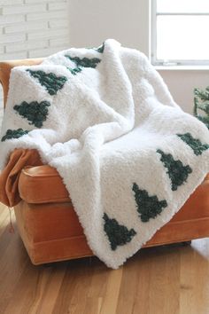 a blanket that is sitting on top of a chair in front of a window,