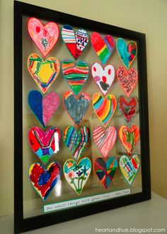 a shadow box filled with lots of different colored heart shaped magnets on top of a table