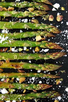 cooked asparagus with garlic and parmesan on a black surface, ready to be served