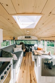 the inside of a camper with wood floors and white appliances on it's walls