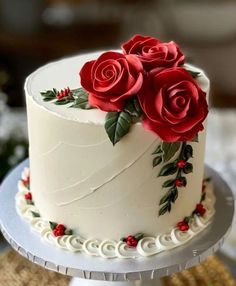 there is a white cake with red roses on it