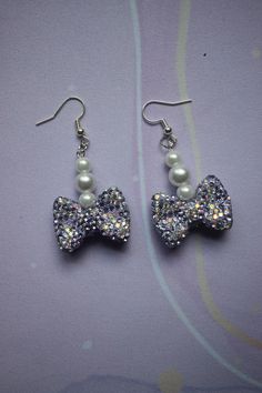 Glam up your outfit with these Sparkling Bow Earrings! Featuring glittery, rhinestone-studded bows with faux pearls, these earrings add a touch of elegance and shine. Perfect for parties or special occasions, they're finished with silver-tone hooks and offer a lightweight, comfortable wear. Earrings Cute, Bow Earrings, Faux Pearl, Jewelry Earrings Dangle, Dangle Drop Earrings, Silver Tone, Dangle Earrings, Jewelry Earrings, Sparkle