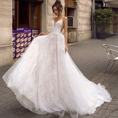 a woman standing in front of a building wearing a wedding dress