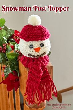 a crocheted snowman post topper sitting next to a potted plant