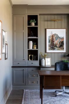 a home office with built in cabinets and desk