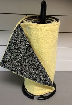 a yellow and black umbrella holder on a gray counter top with white wall in the background