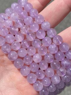 a hand holding some purple beads in it