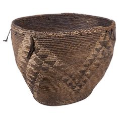 a large woven basket with handles on the front and side, in brown color scheme