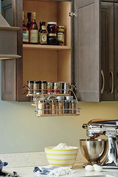 a kitchen with wooden cabinets and shelves filled with cooking utensils on the counter