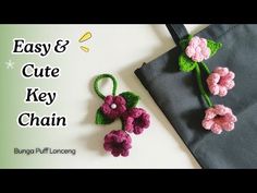 two crocheted flowers sitting on top of a black bag with the words easy and cute key chain