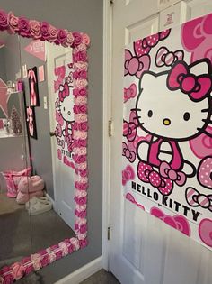 a hello kitty themed bathroom with pink roses on the door and mirror in the doorway