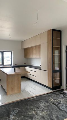 an empty kitchen with wooden cabinets and black counter tops in front of a large window