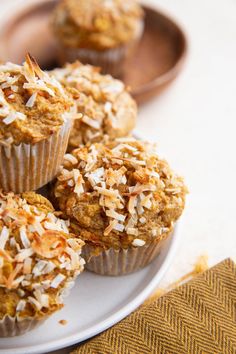 some muffins are sitting on a plate with coconut flakes all over them