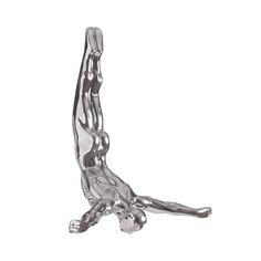 a silver figurine sitting on the ground with its legs spread out and feet crossed