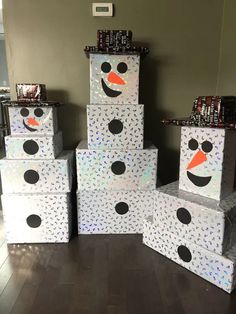 several boxes with snowman faces are stacked on top of each other in front of a wall