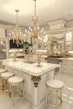 a large white kitchen with gold accents and chandelier