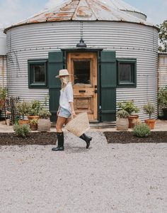 a woman walking in front of a round building